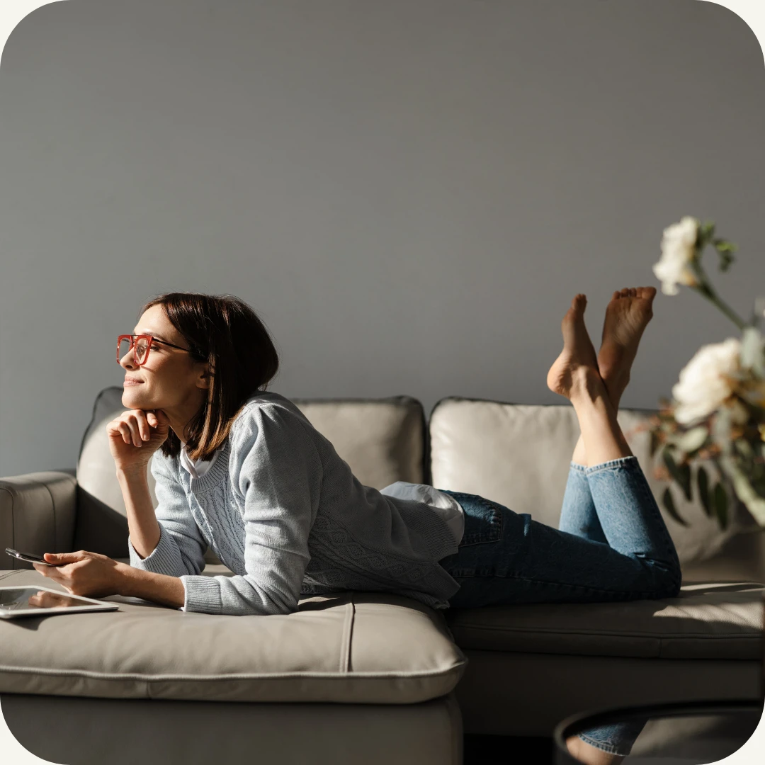 smilende kvinne ligger på sofa