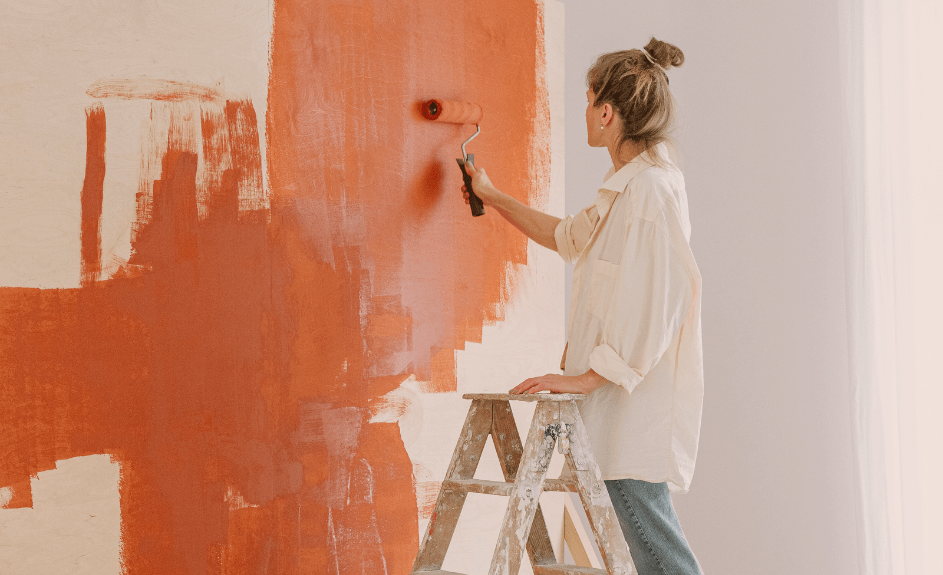 Kvinne maler vegg etter lån til oppussing