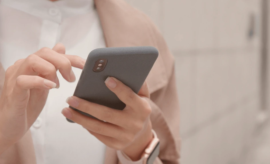 Kvinne med mobiltelefon i hånden