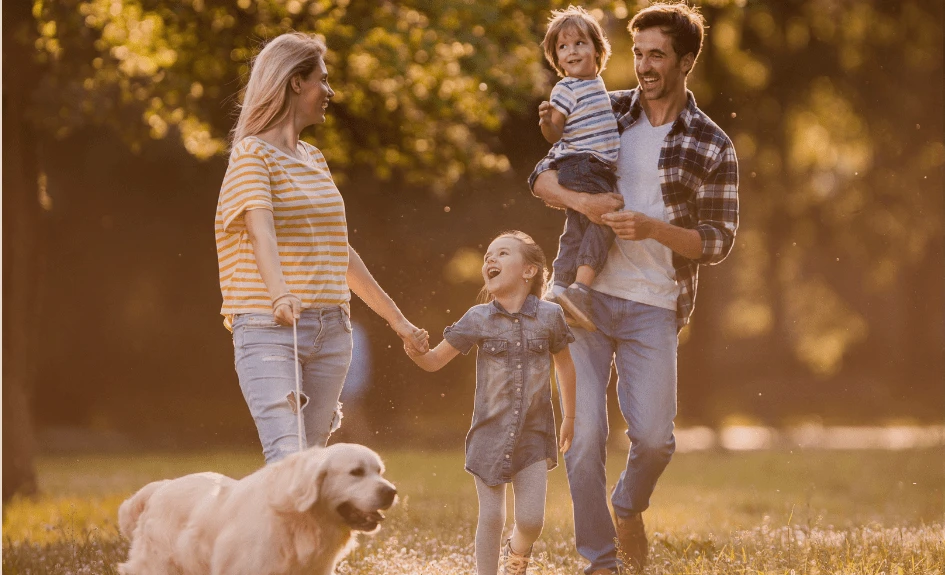 Smilende familie og Golden Retriever-hund