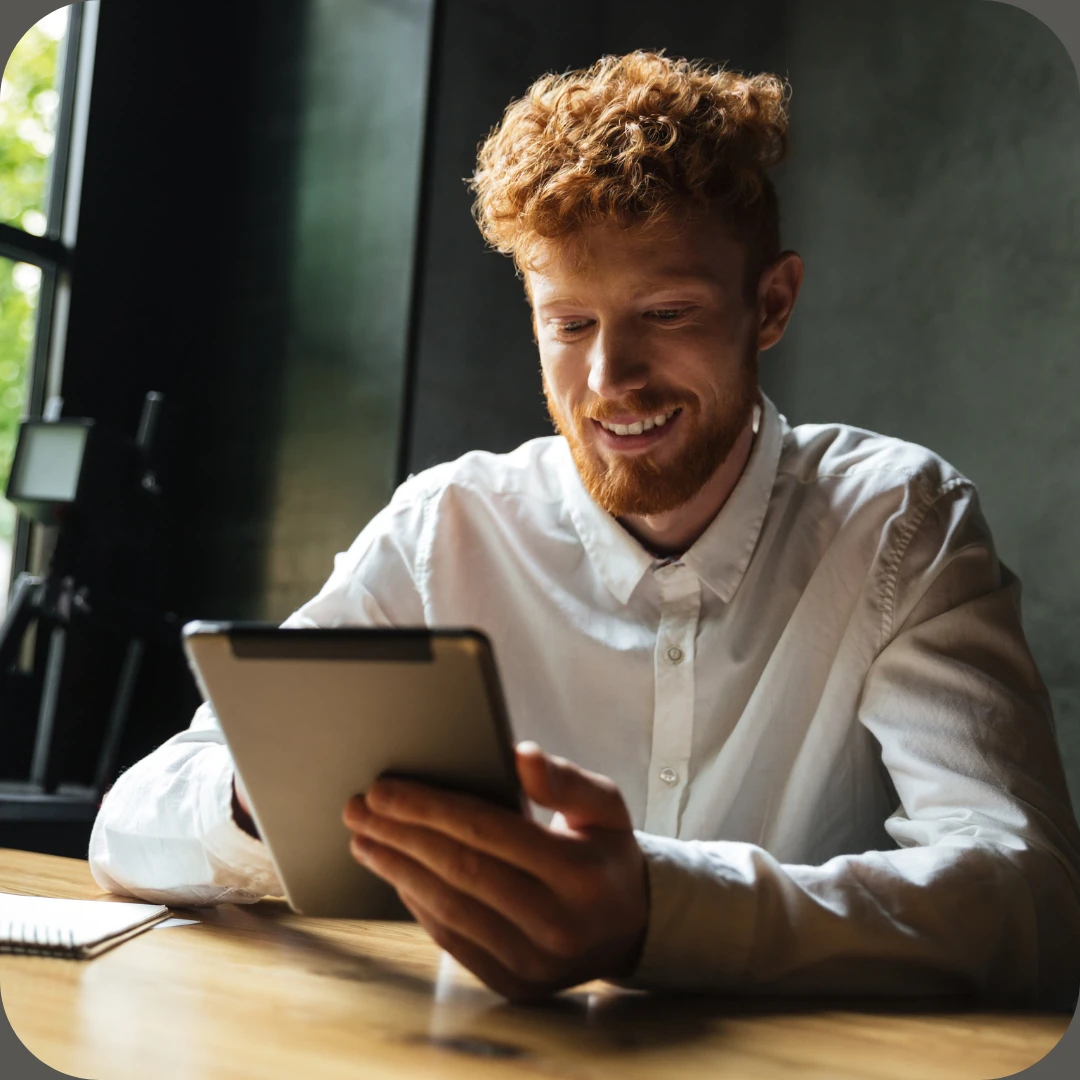 smilende mann serpå nettbrett