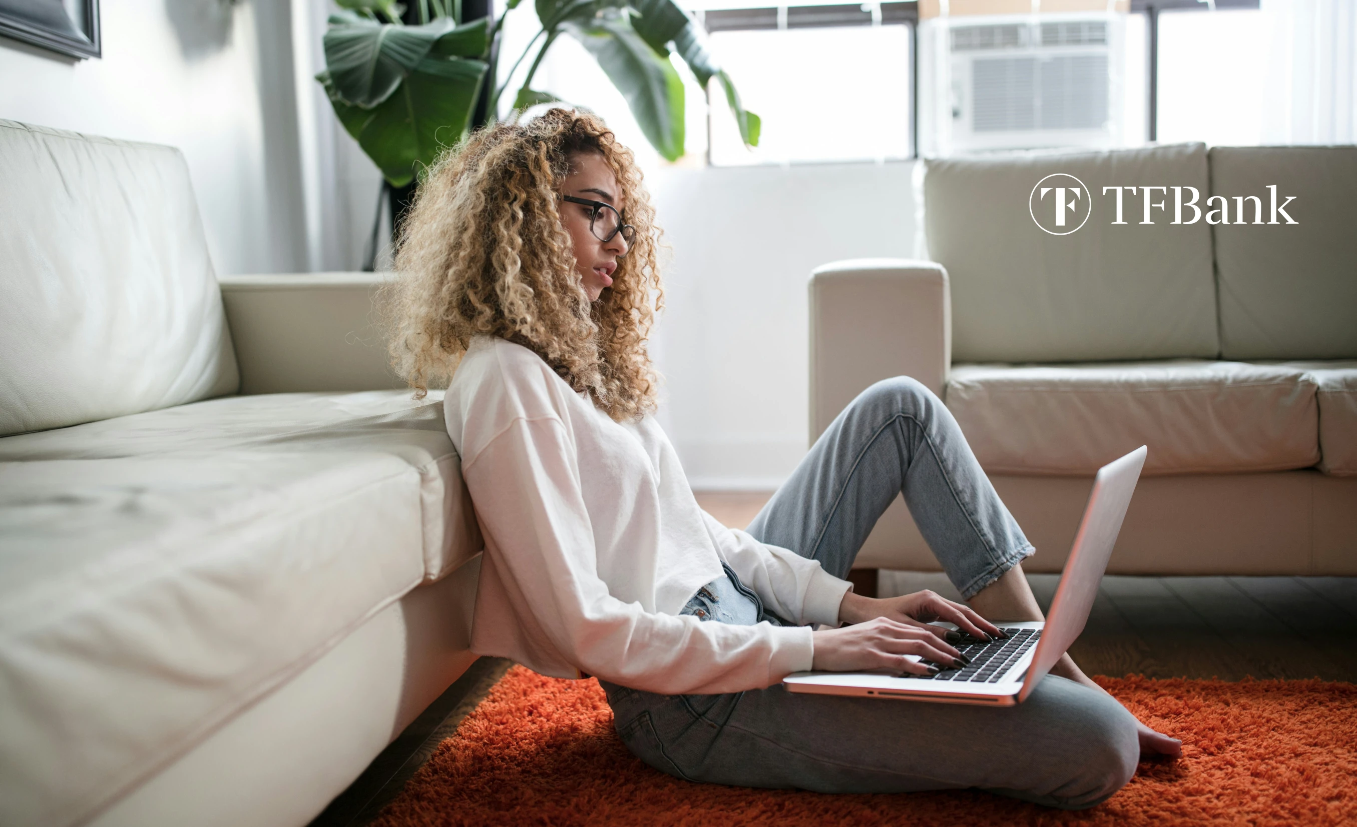 Ung kvinne sitter på gulv med pc