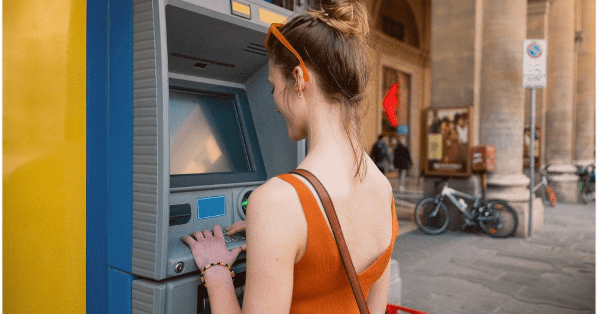 kvinne bruker kort i utlandet minibankuttak 