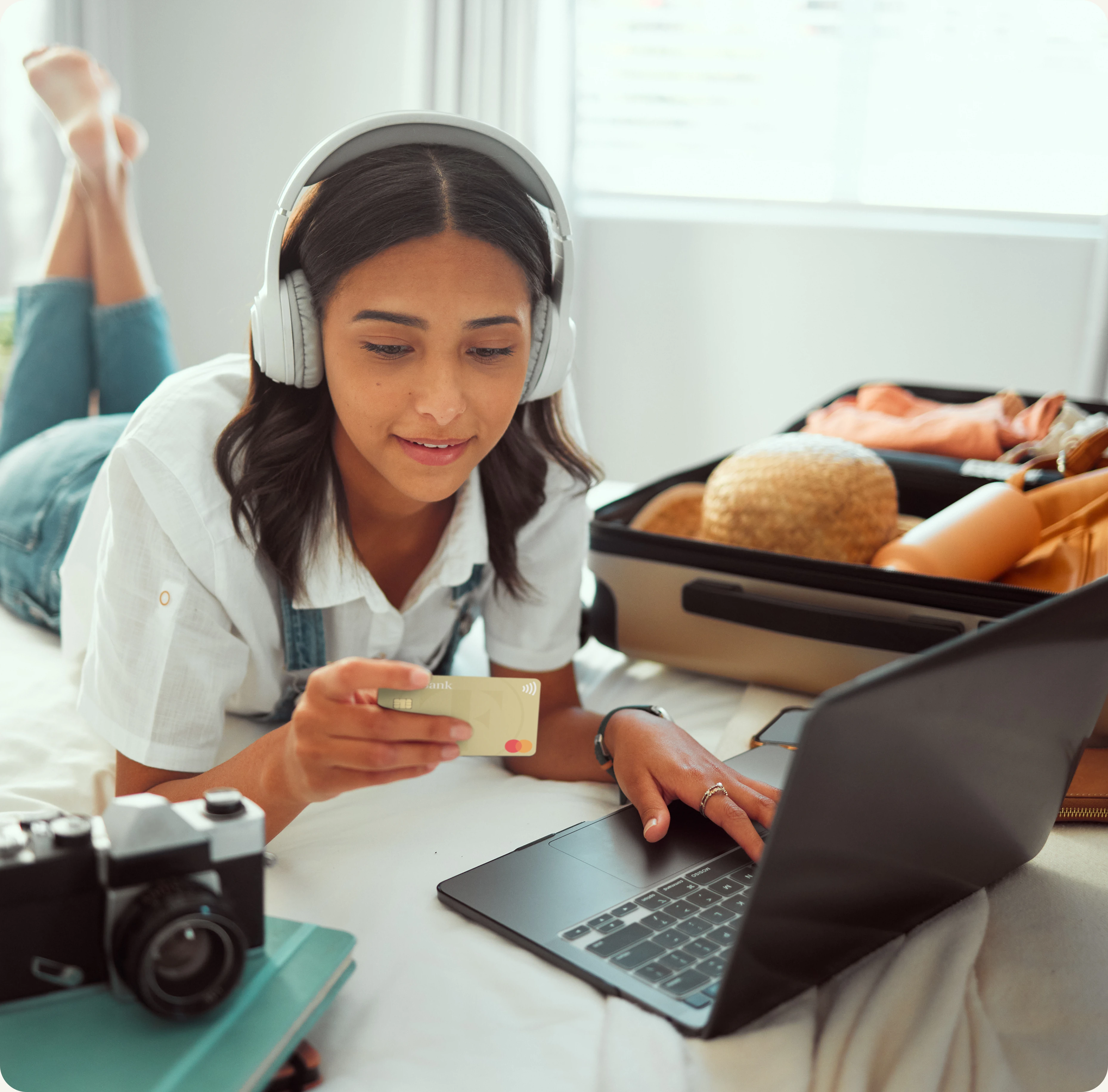 woman lying on bed holding tf bank mastercard
