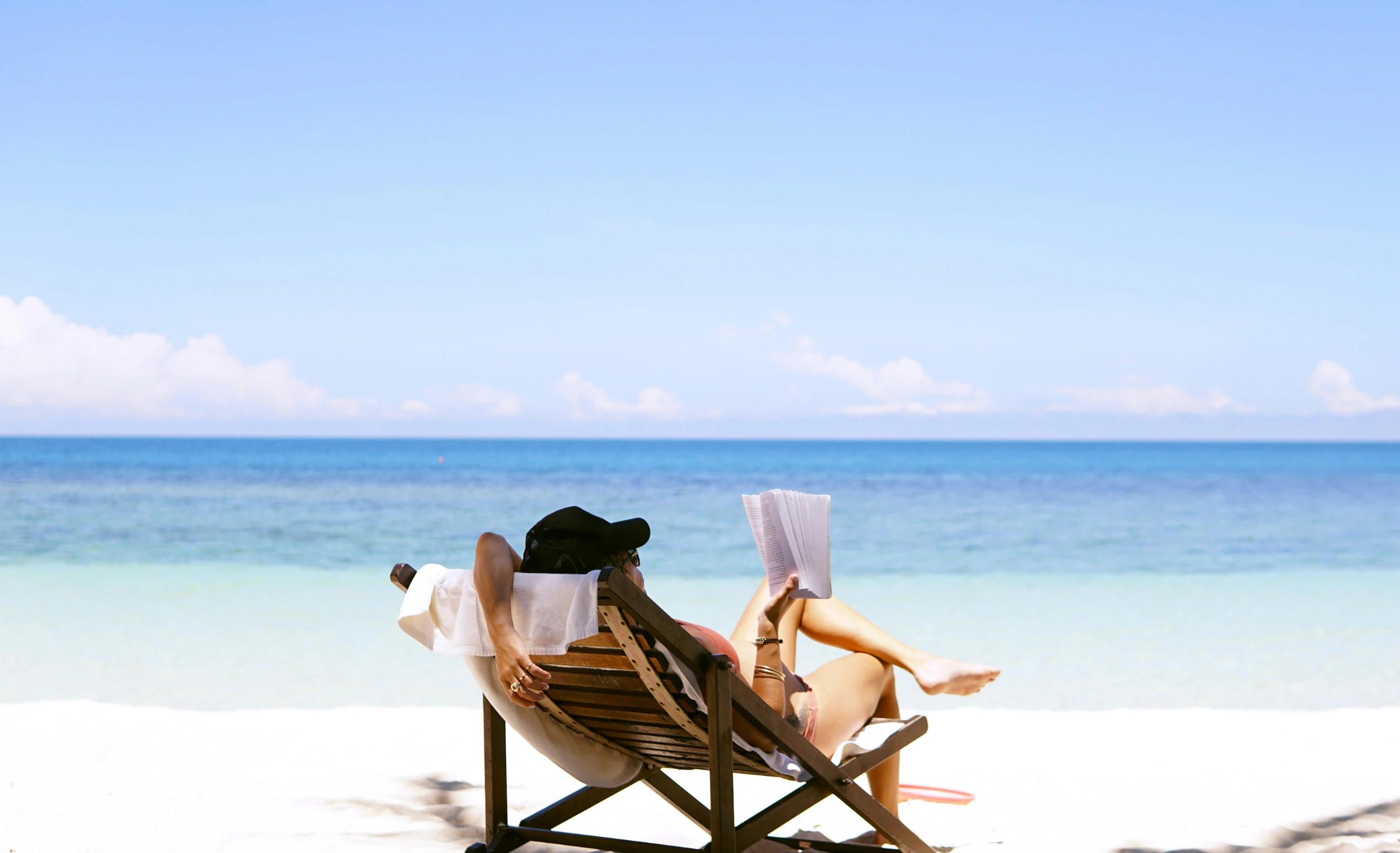 Dame leser bok på tropisk strand