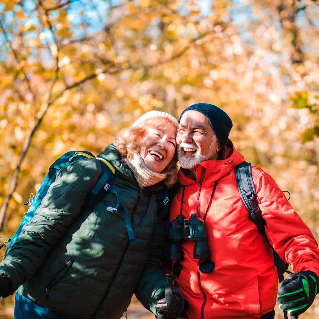 Smilende mann og kvinne på tur i høstværet
